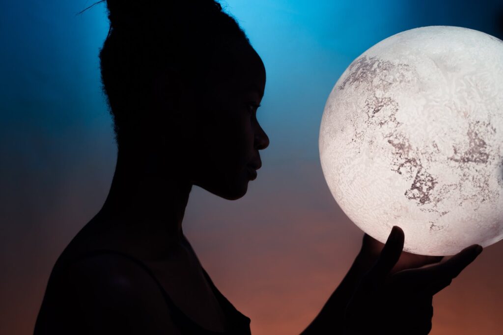 silhouette of woman holding moon