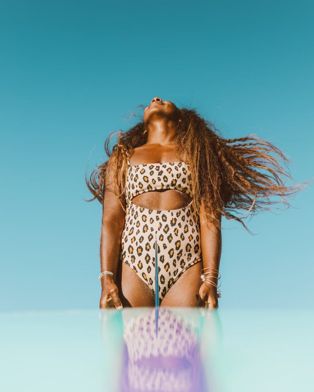 woman in a swimming suit throwing her head back