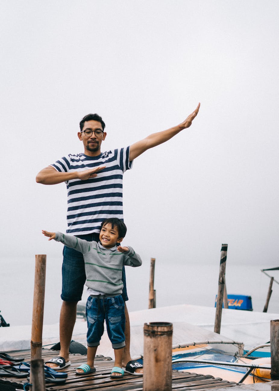 father and son posing on a wooden dock