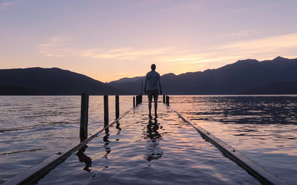 person standing on dock with water