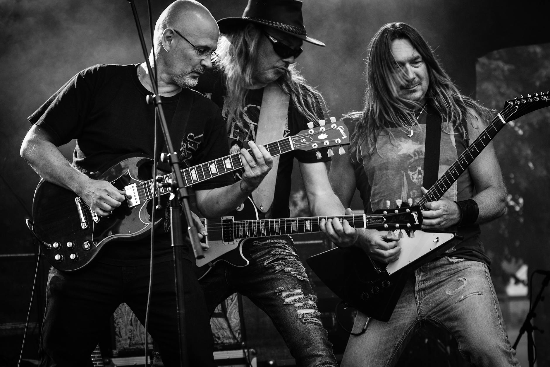 group of men playing guitar in concert in grayscale photo