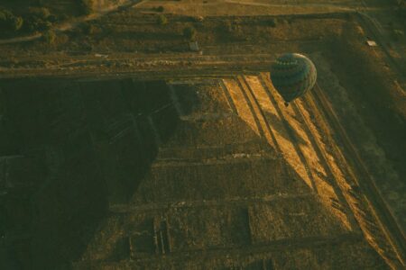 hot air balloon floating over pyramid