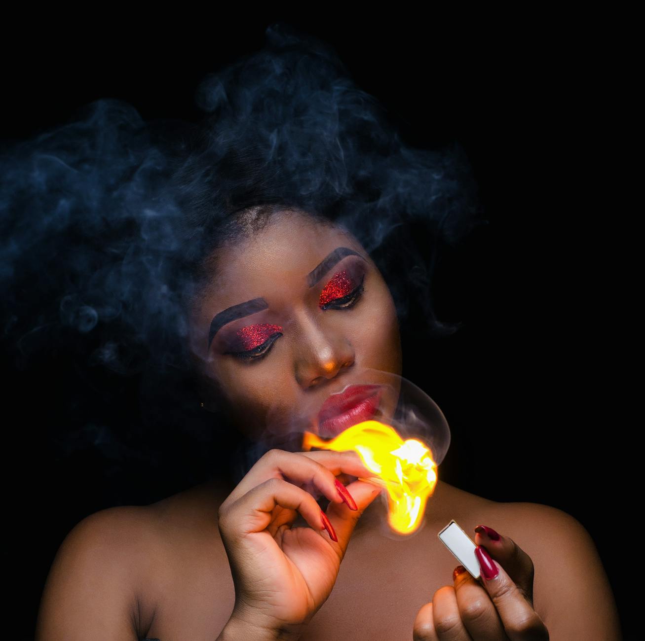 photo of a woman holding match stick with fire