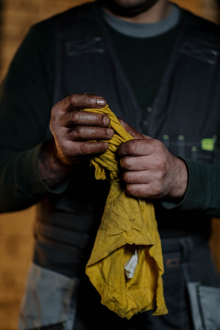 man with dirty hands and rag in workshop