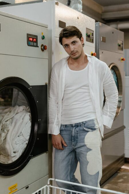 a man in white long sleeves leaning on washing machine