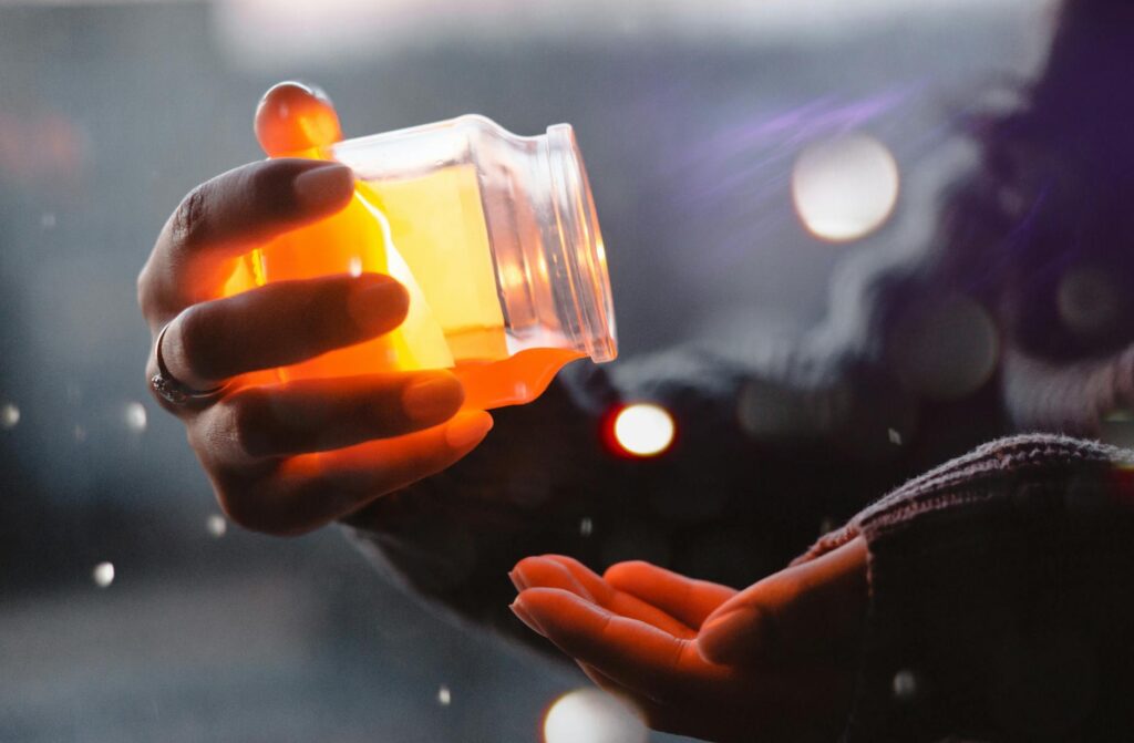 person about to pour yellow liquid on palm