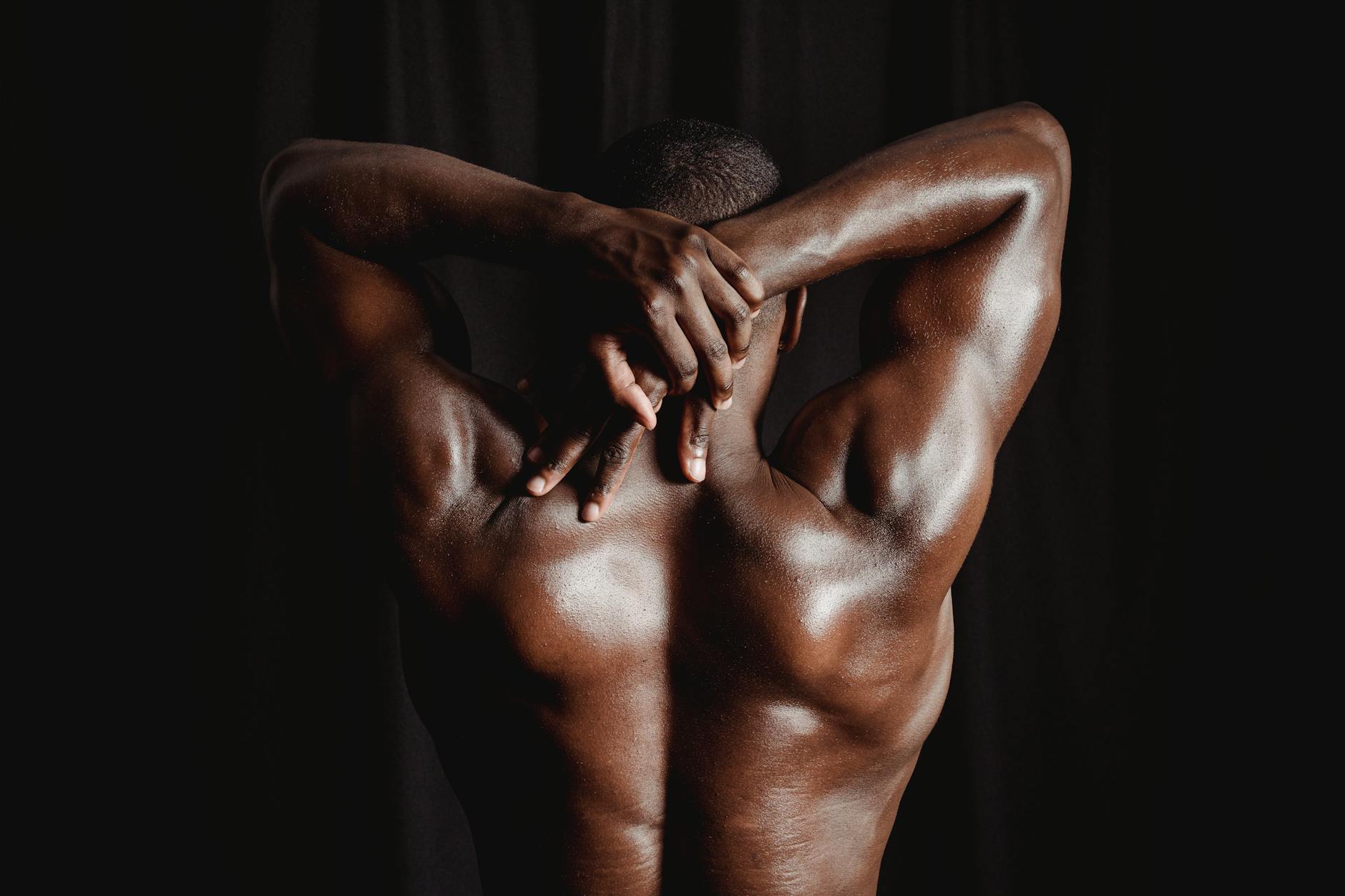 back view of man posing shirtless showing muscles