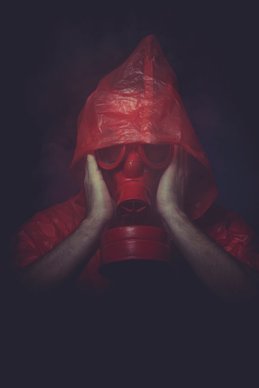man in red plastic jacket wearing red gas mask