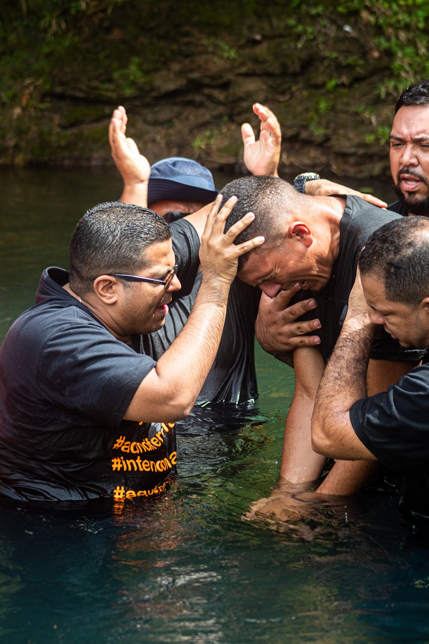 group of men standing waist deep in water crying