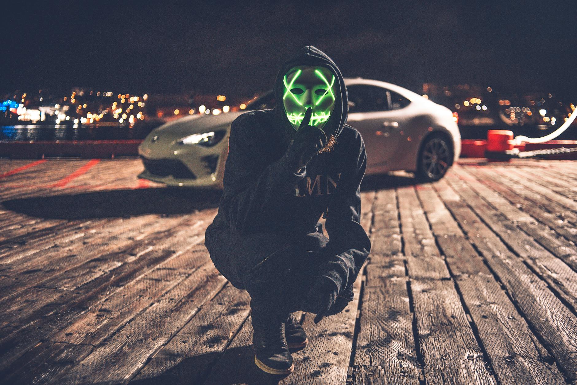 person wearing black and green mask and black jacket