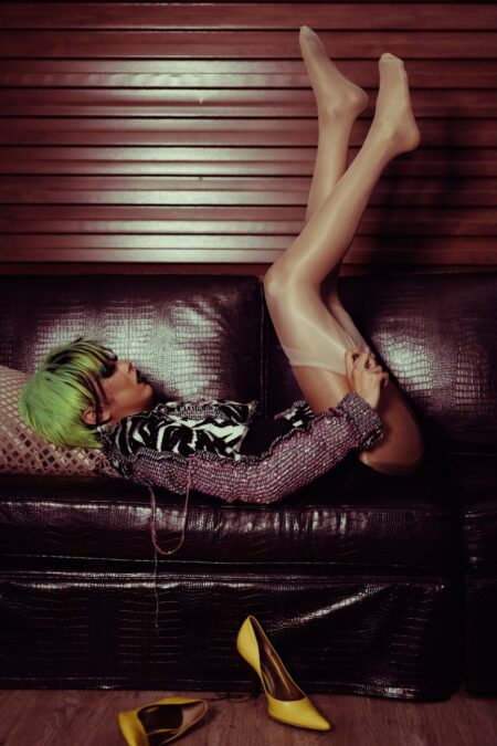 transgender woman lying on sofa with legs raised alluringly