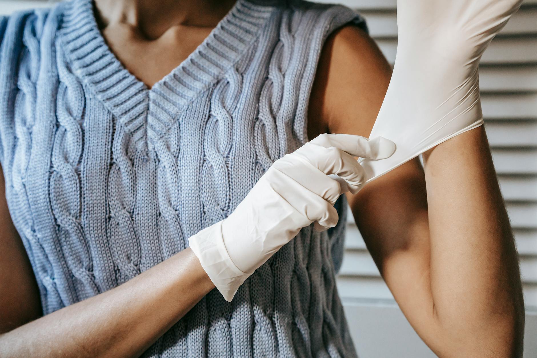 unrecognizable woman putting on rubber gloves