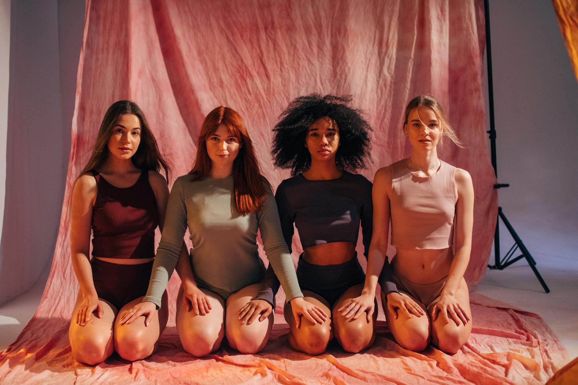 women posing together while kneeling on the floor