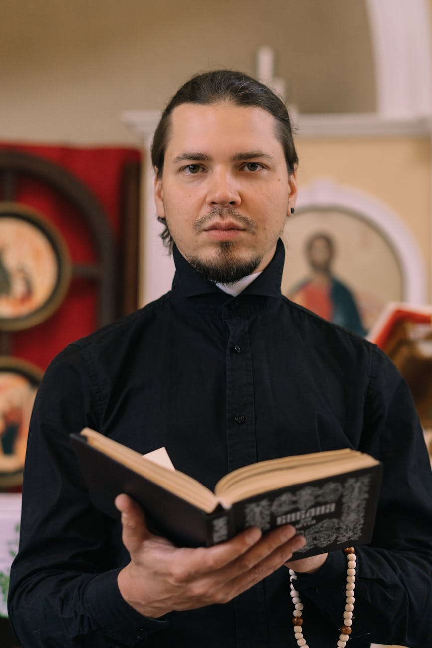 man with a beard holding a bible and rosary