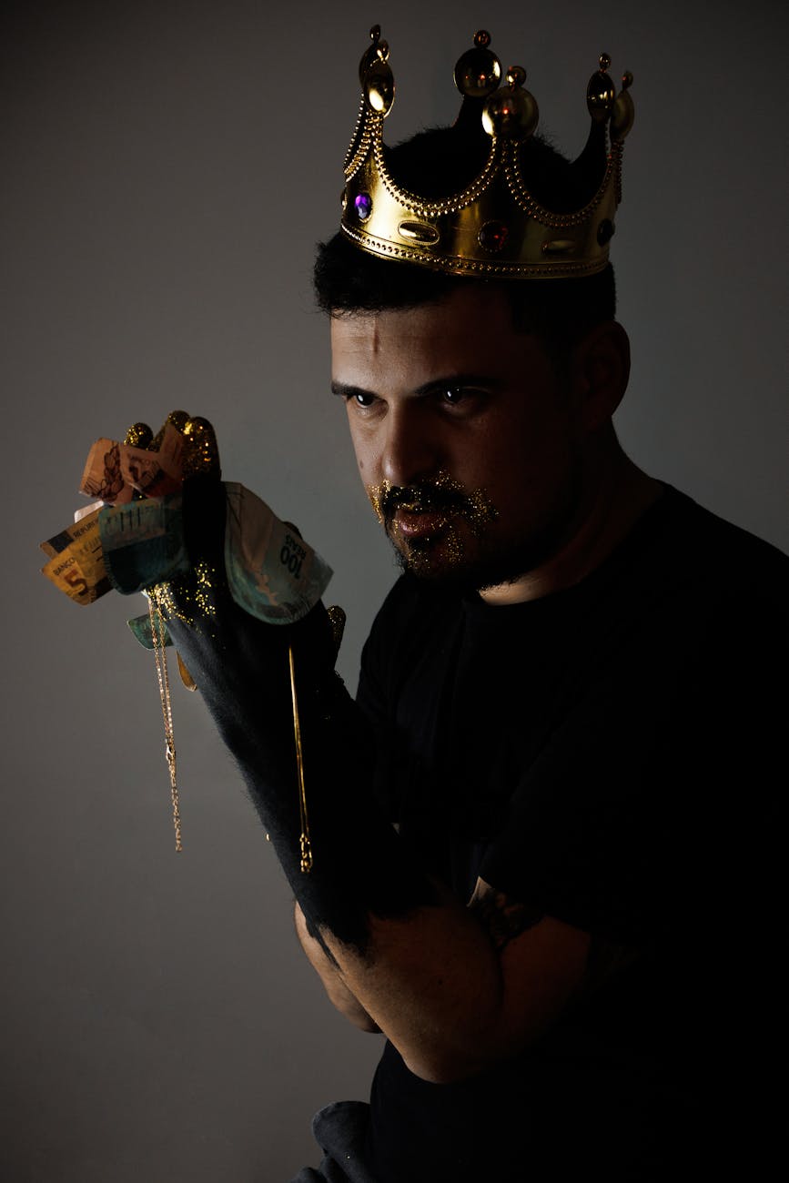 man in a crown holding banknotes
