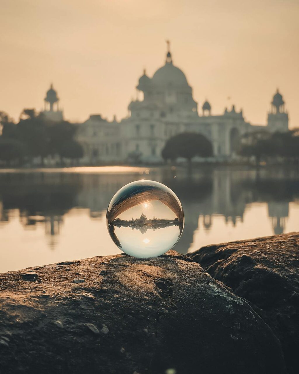 monumental building reflecting in crystal ball set on stone