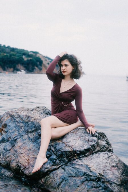 elegant woman posing on rocky beach