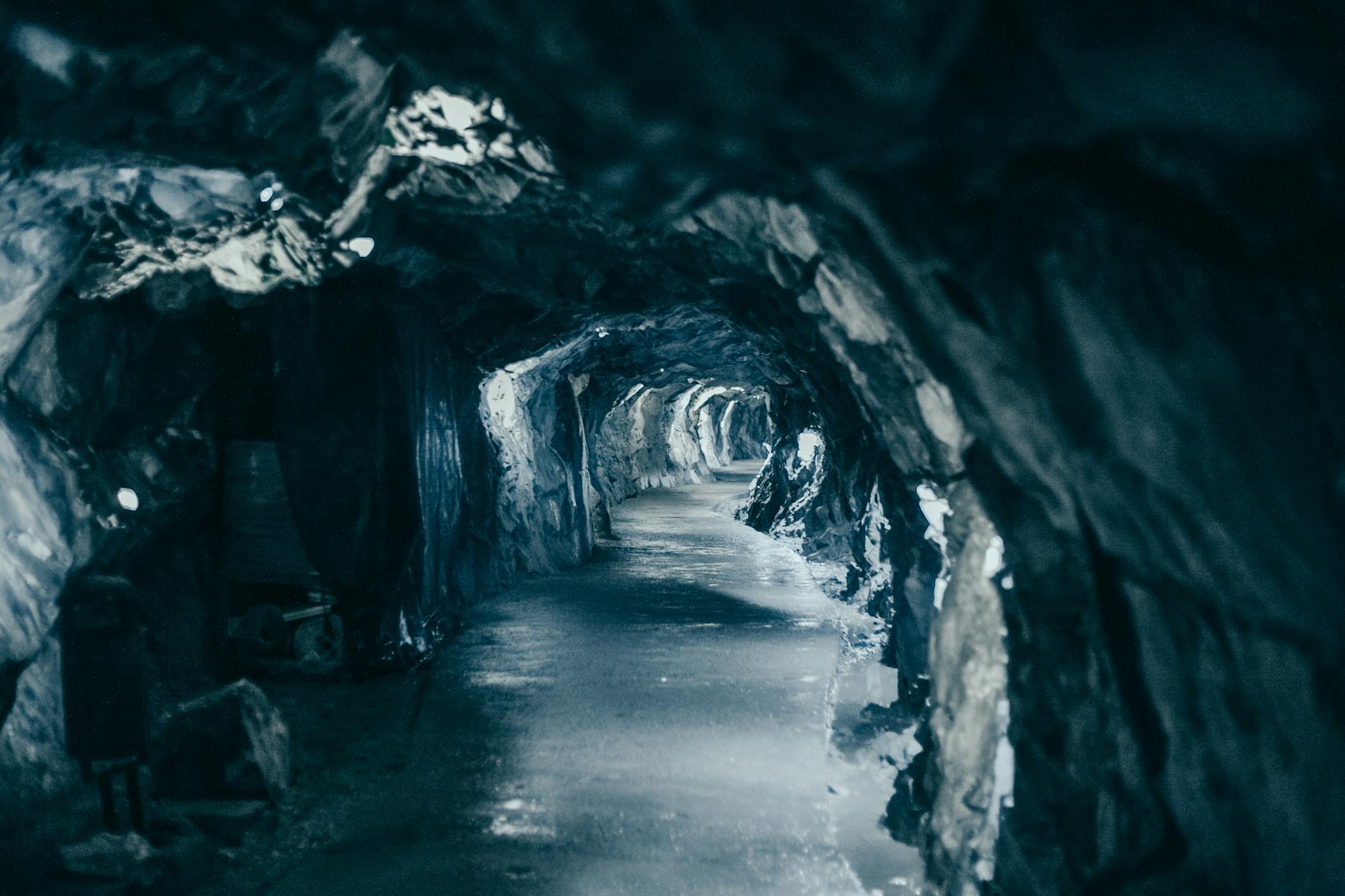 grayscale photo of an illuminated tunnel