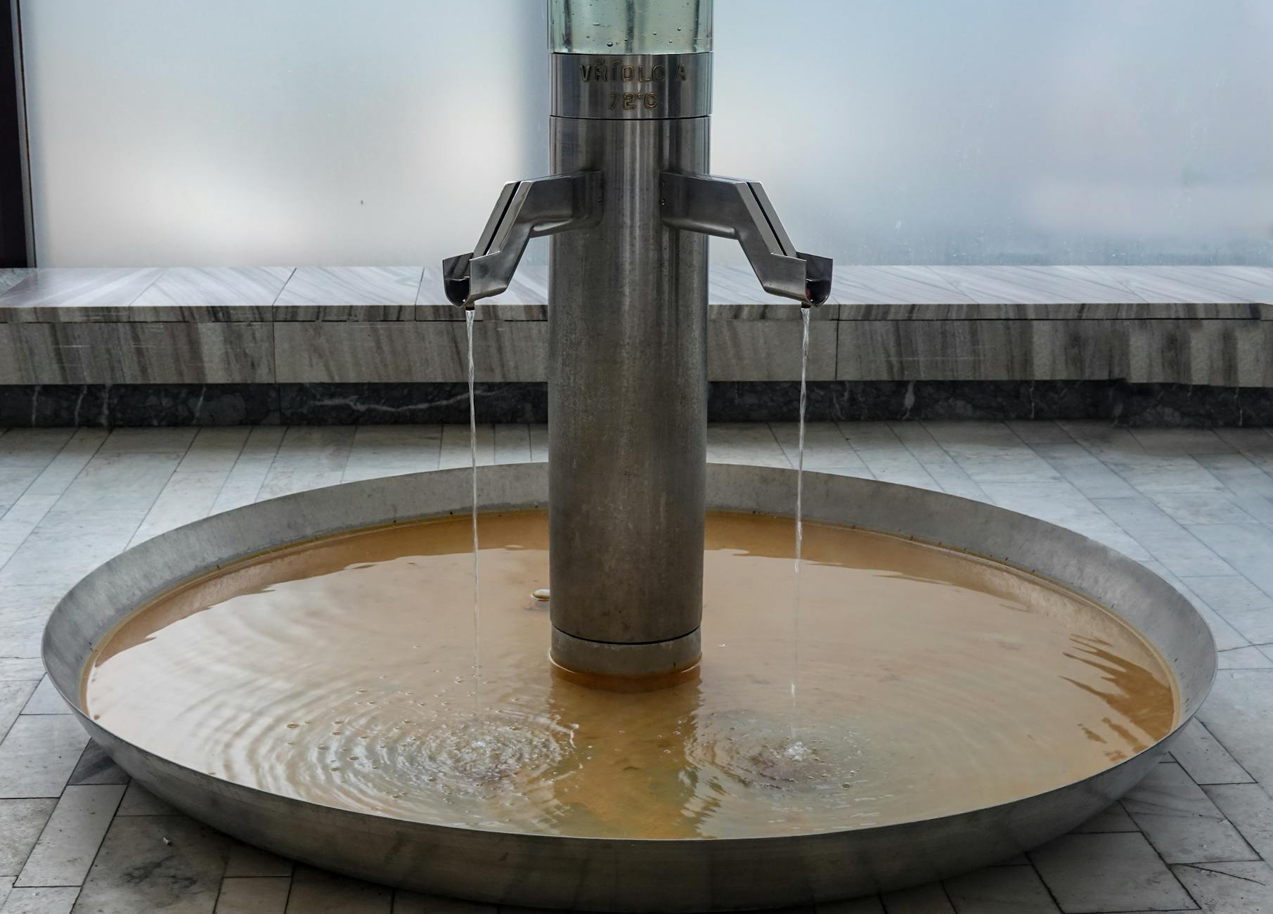 close up of a water fountain with a metal bowl