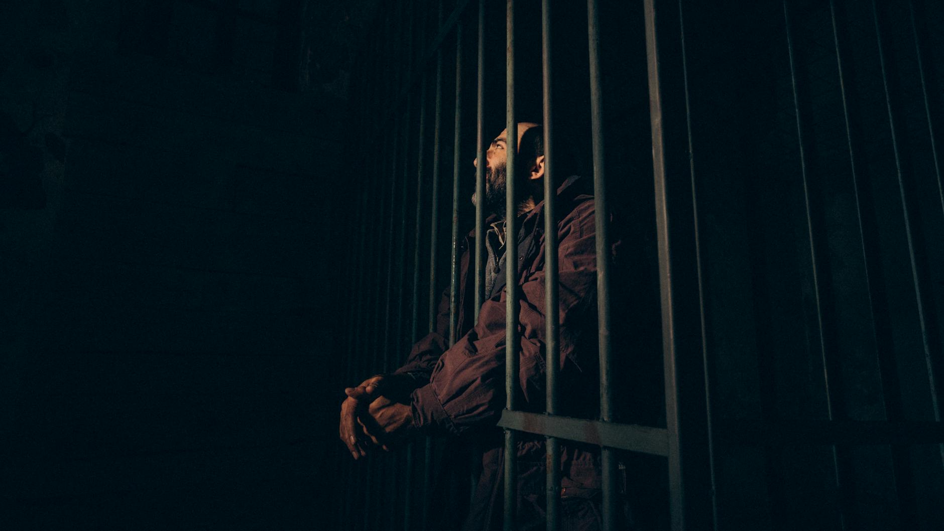 a prisoner standing behind the bars