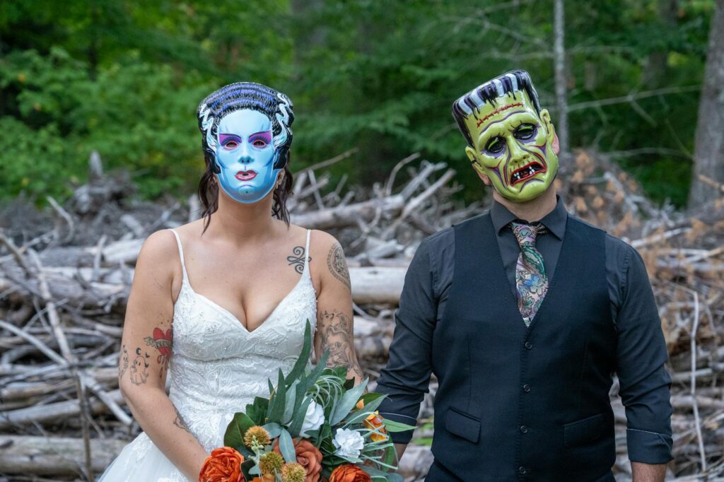 bride and groom in horror masks outdoors