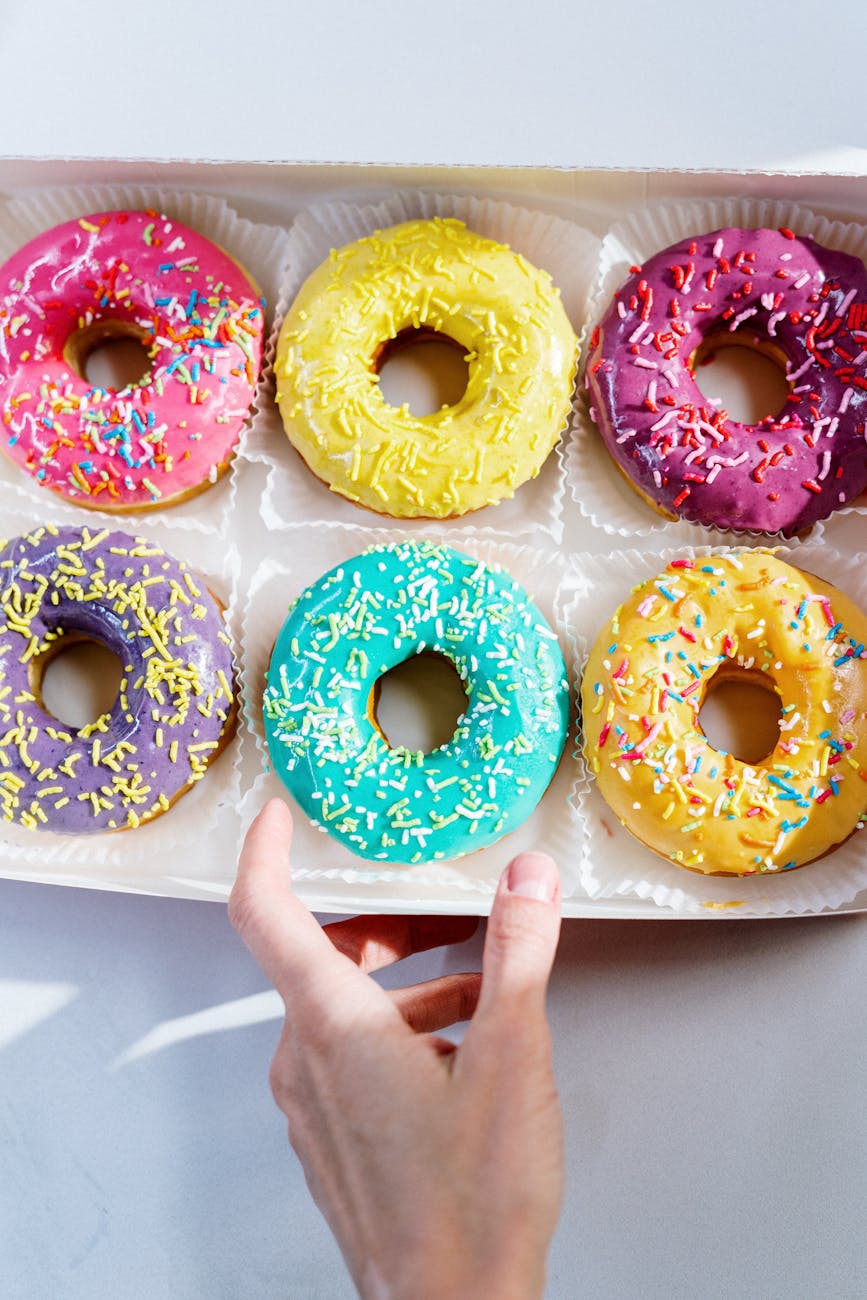 person holding white and pink doughnut