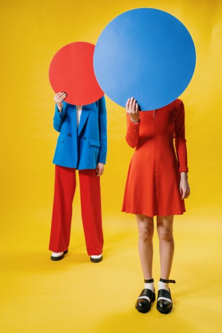 people holding colored round cardboard