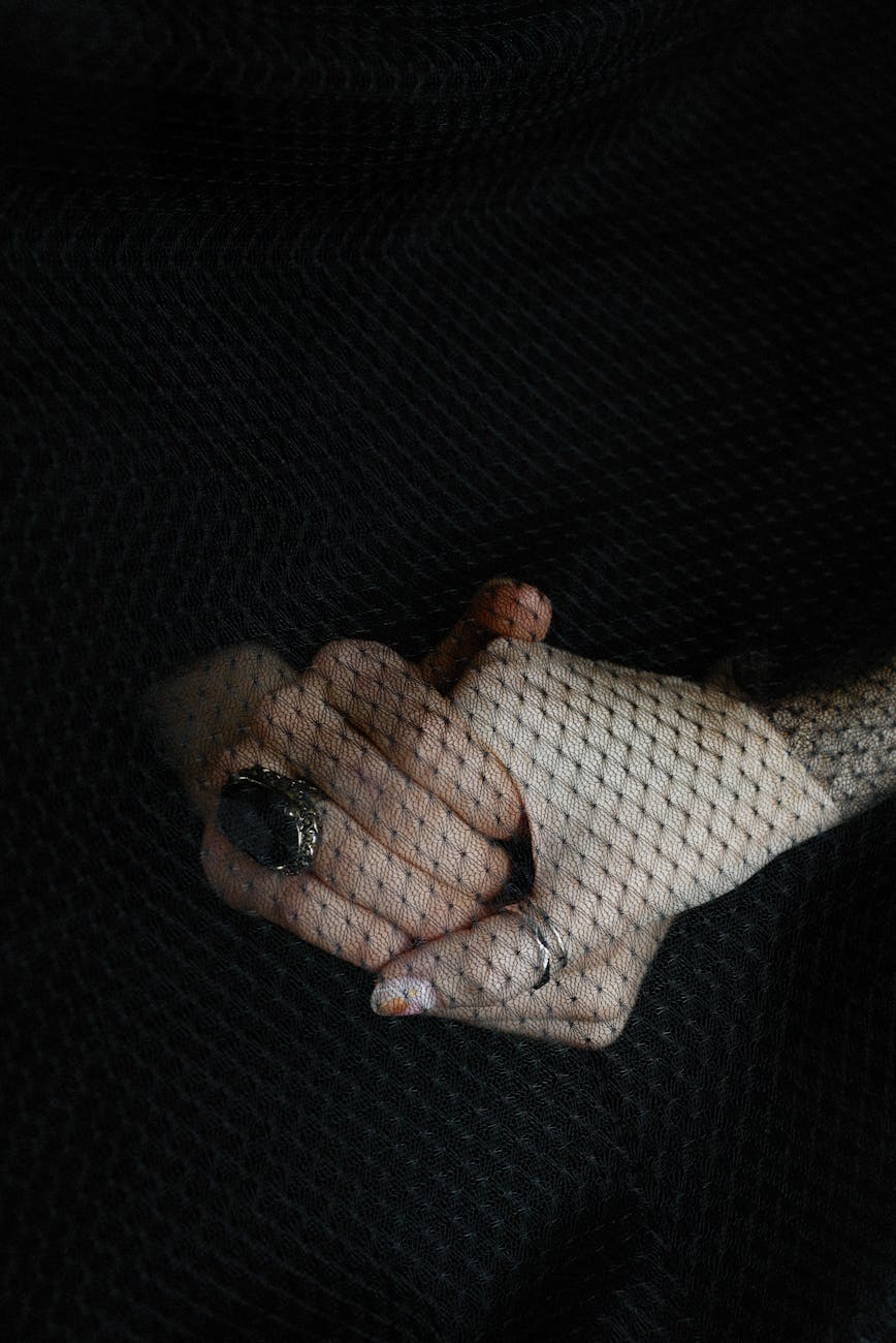 womans hands behind a black veil