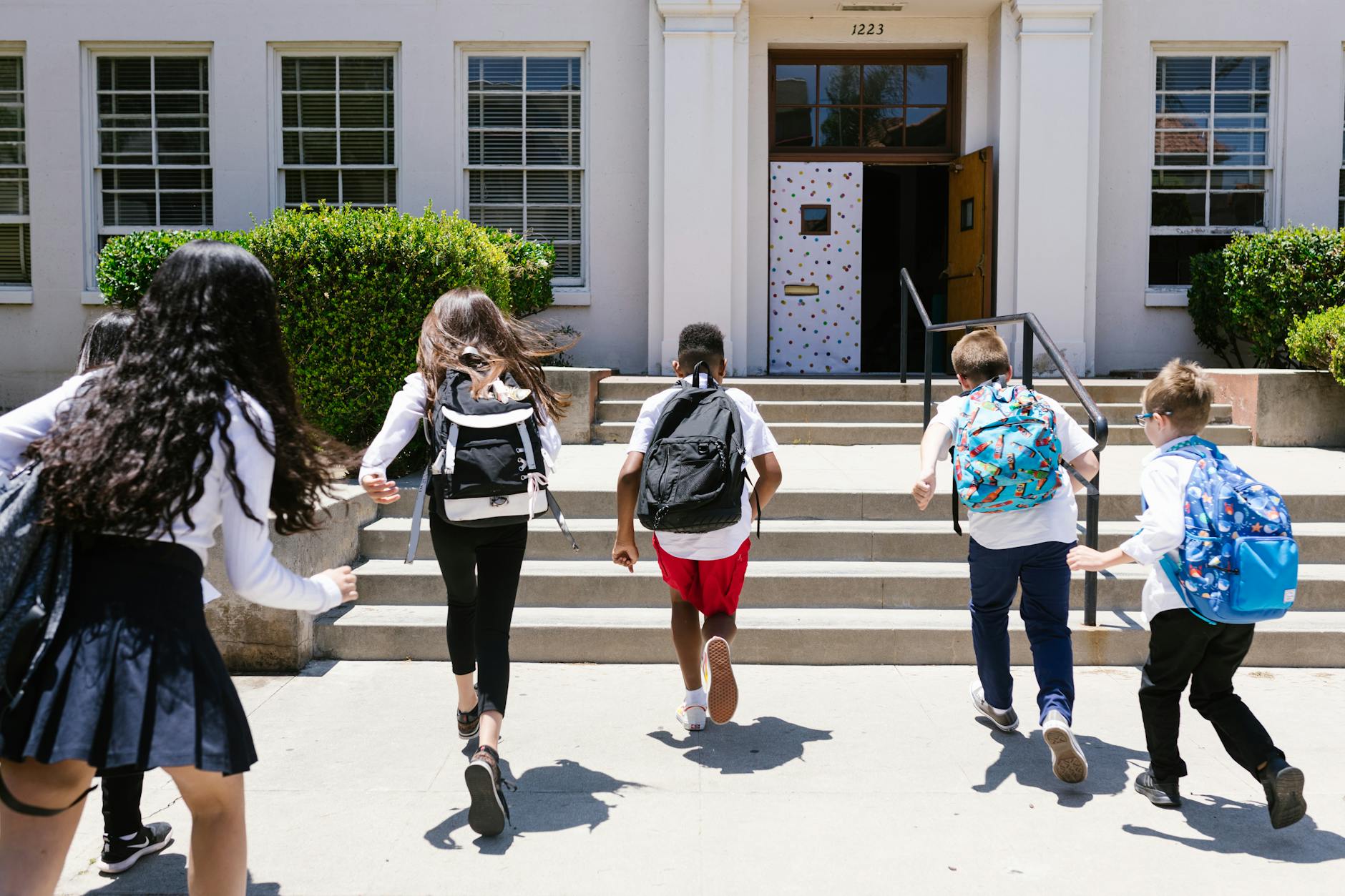 back view shot of students running to their classroom