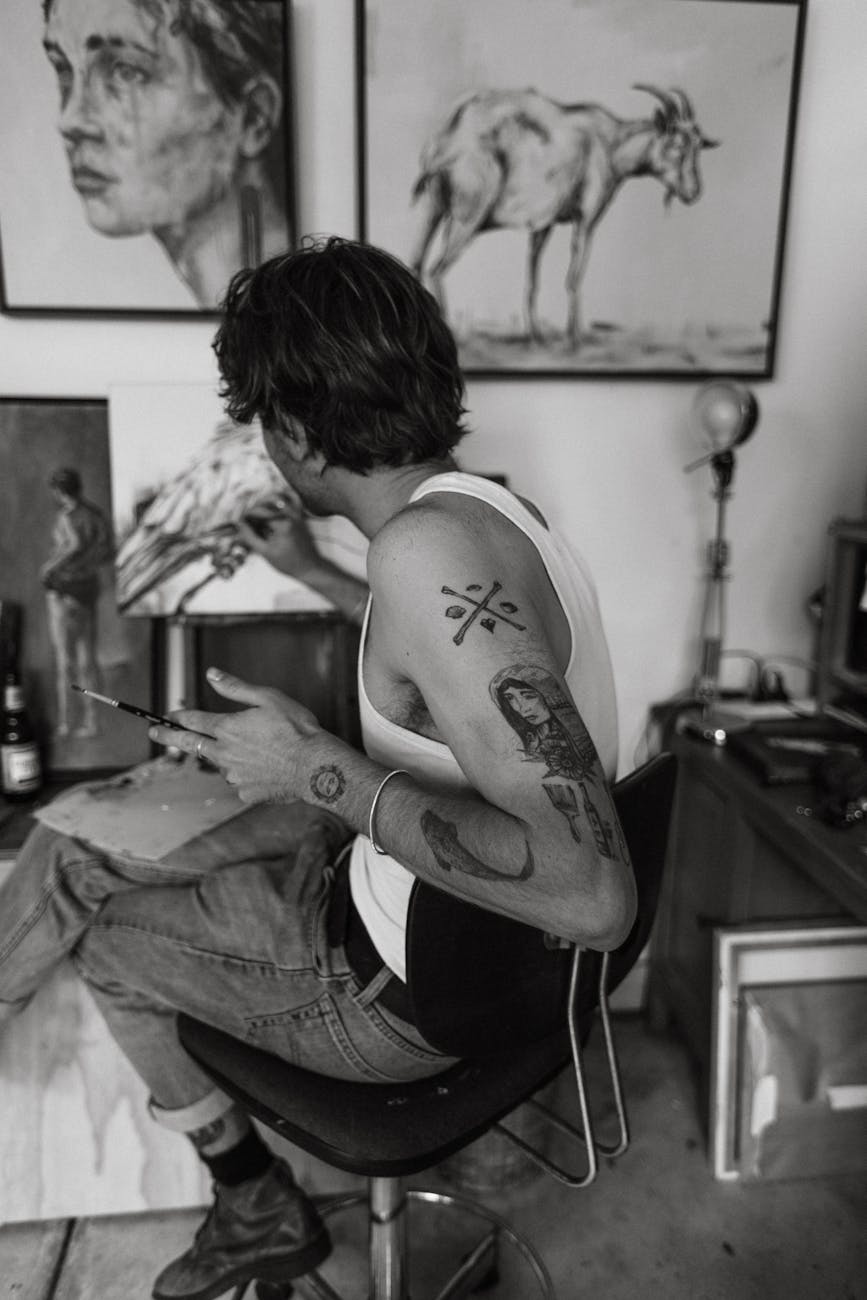 unrecognizable man painting in studio