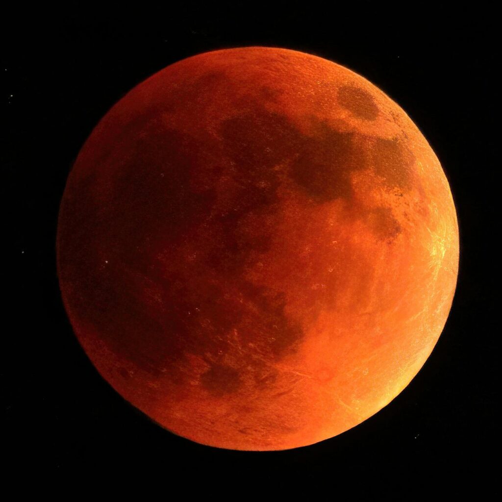 orange moon in black background