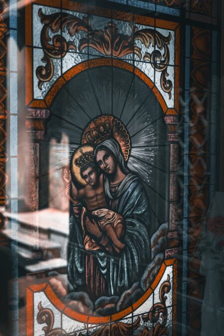 saint mary with jesus depicted on stained glass in church