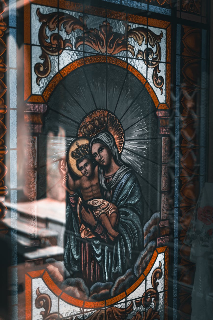 saint mary with jesus depicted on stained glass in church