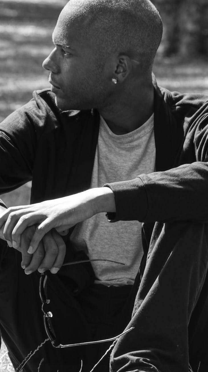 sitting on grass man holding sunglasses in his hands