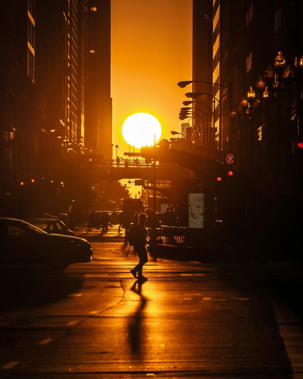 silhouette of person walking on road during sunset