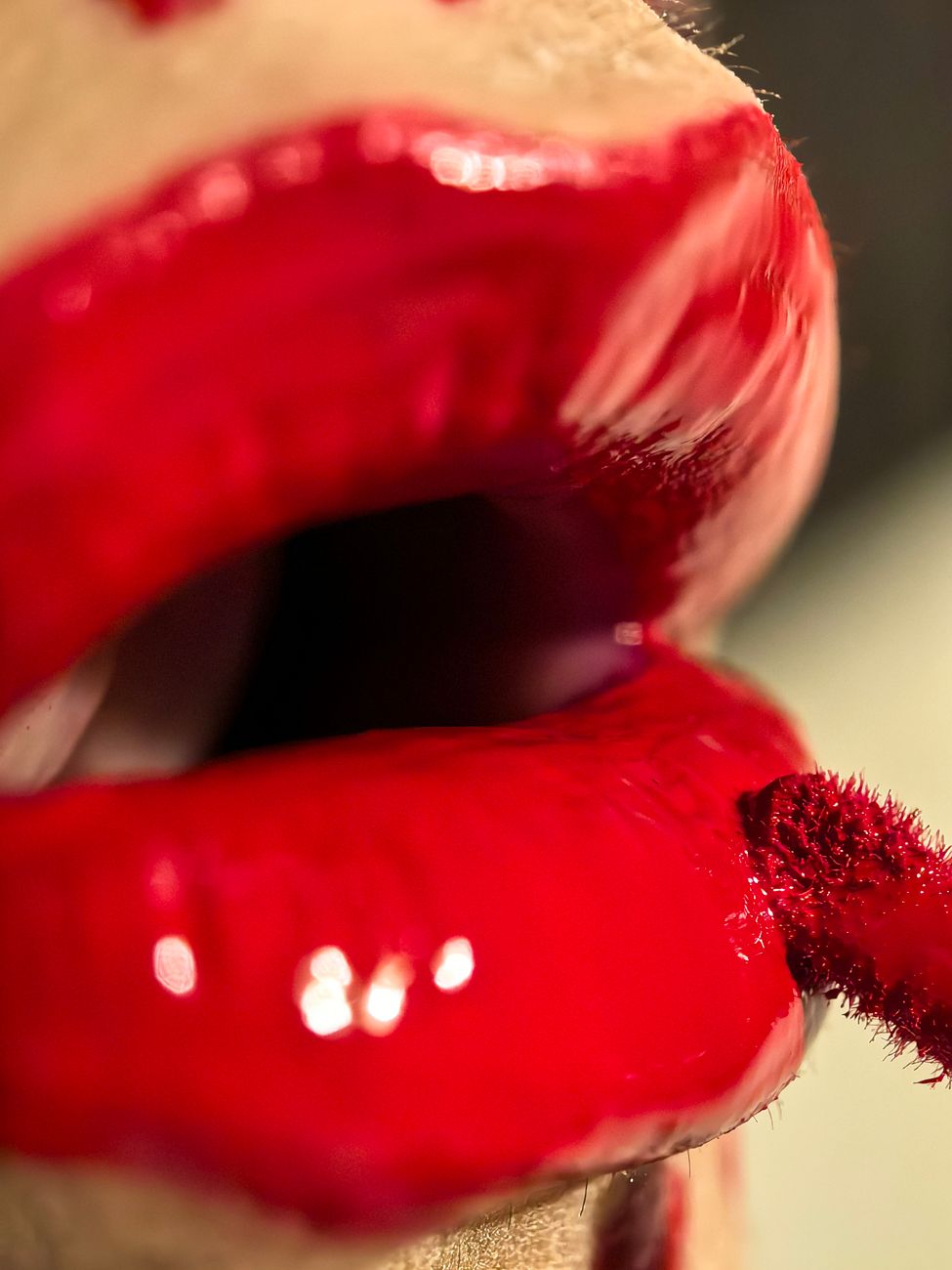 close up of glossy red lipstick application