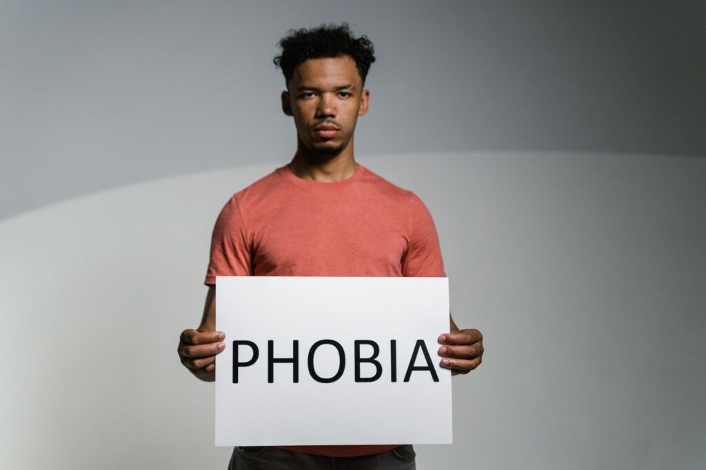 a man holding a sign of phobia